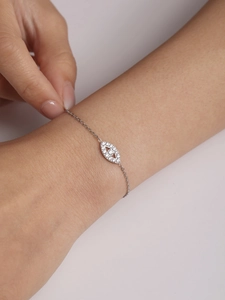 Detailed close-up of a zircon-encrusted Evil Eye bracelet in polished titanium steel