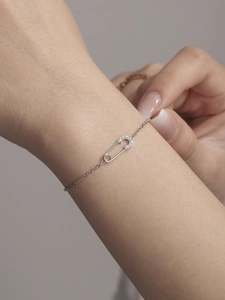 Detailopname van een zilveren veiligheidsspeld ketting met glinsterende kristallen