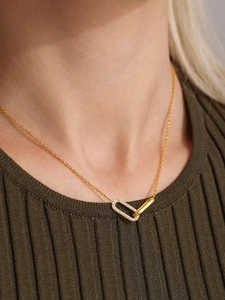 Close-up of interlocking square and oval pendant with pavé set zircon on a gold chain