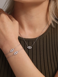 Detailed view of silver Evil Eye jewelry set with micro-pave zircons on a model