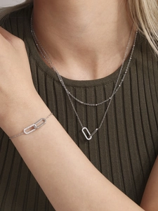 Macro detail of a layered stainless steel necklace and bracelet set with pave zircon links