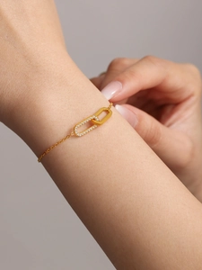 Close-up of gold interlocking rectangular links with pavé zircon on a dainty chain bracelet