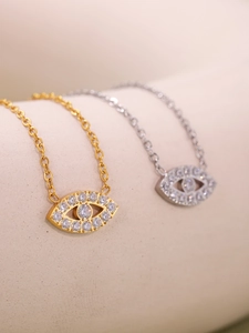 Detail of gold and silver evil eye necklaces with marquise-cut zircon pavé setting