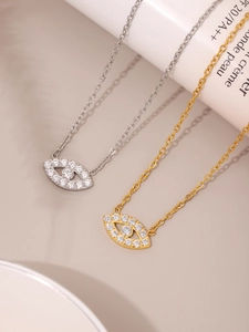 Close-up of gold and silver Evil Eye necklaces with zircon inlay and stainless steel chain