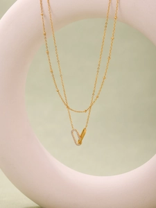 Detailed close-up of double-layered gold chain necklace with zircon encrusted interlocking rings