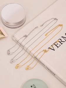 Detailed view of interconnected square zircon pendants on gold and silver layered necklaces