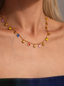 Close-up of colorful heart pendants on a gold stainless steel necklace on a model