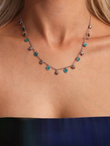 Close-up of heart-shaped pendant necklace with colorful enamel on a model's collarbone