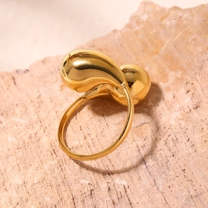 Polished 18K gold-plated stainless steel teardrop open ring on a natural stone base