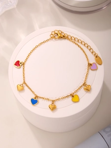 Close-up of golden stainless steel bracelet with colorful enamel heart charms