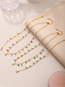 Detailed view of colorful enamel heart pendants on a gold stainless steel necklace set