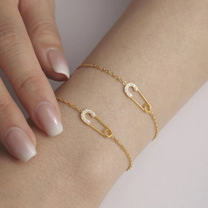 Goudkleurige veiligheidsspeld armbandset met 5A zirkonia op fijne kruisketting