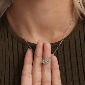 Evil eye necklace in silver finish with sparkling zircon inlay worn by a model