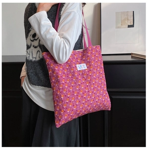 Detail of pink floral tote bag with textured crinkle fabric and branded label