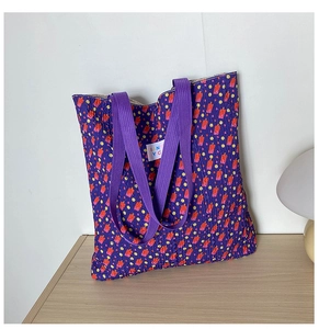 Detailed macro of floral pattern fabric with TIANYC brand label on purple tote bag