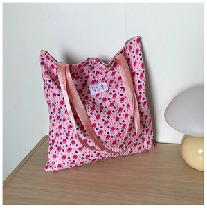 Detailed view of pink floral canvas tote bag on wooden table with a mushroom lamp