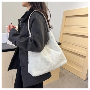 Détail d'un sac cabas en fausse fourrure blanche porté avec un manteau en laine chic