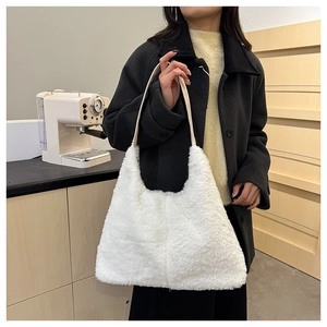 Détail d'un grand sac à main en peluche blanche avec poignée sur fond d'intérieur épuré