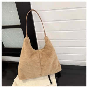 Detail of soft light brown plush faux fur fabric on a shoulder bag with leather strap