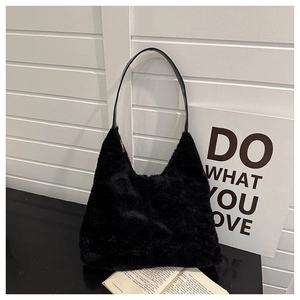 Détail d'un sac à bandoulière en fourrure noire avec texture douce et fine sangle en cuir