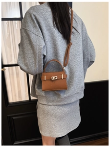 Vue arrière du sac à main marron motif litchi porté en bandoulière par un mannequin