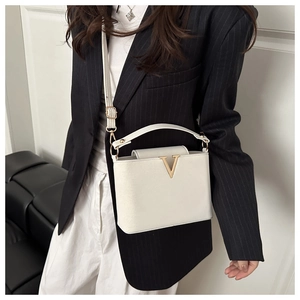White faux leather crossbody bag with elegant gold V-shaped buckle hardware detail