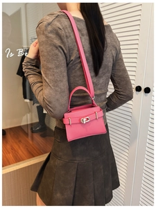 Model showing a magenta mini square leather bag with silver metal twist lock and top handle