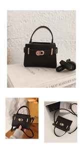 Detail of black pebbled leather handbag with golden twist lock and adjustable strap