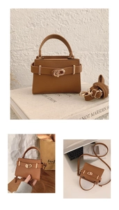 Macro detail of dark brown pebble leather mini crossbody bag with gold belt buckle lock