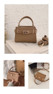 Detailed view of brown litchi leather handbag with gold buckle and adjustable strap