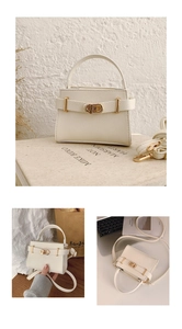 Detail of lychee textured cream crossbody bag with golden buckle and sleek handle