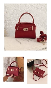 Detail view of red lychee textured handbag with gold metal lock and shoulder strap
