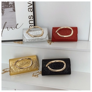 Detail of four colorful pebbled leather bags with oversized gold metal buckles and chains