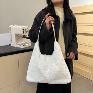 Chic white faux fur shoulder bag for women with leather strap in a cozy indoor setting