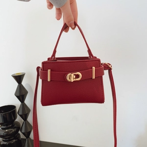Elegant red lychee texture crossbody handbag with gold hardware and trapezoid structure