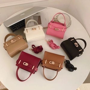 Mini sacs bandoulière en cuir grainé de diverses couleurs sur un bureau chic