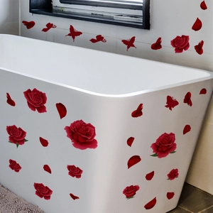 Detail of red rose petals and butterfly stickers on a white bathtub in the bathroom