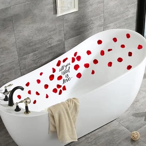 Close-up of 'all you need is love' bathroom wall sticker with red rose petals decor