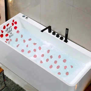 Detail of white bathtub with floating rose petals and all you need is love wall sticker