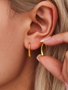 Close-up of teardrop hook earrings in 18K gold plated stainless steel on a model