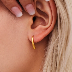 Minimalist teardrop earrings in 18K gold plated stainless steel shown on model ear