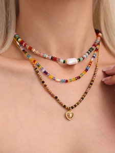 Detail of layered beaded necklace with rectangle pearl, crystal beads and heart pendant