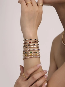 Detail of elegant gold-plated tennis bracelets with colorful rectangular gemstones
