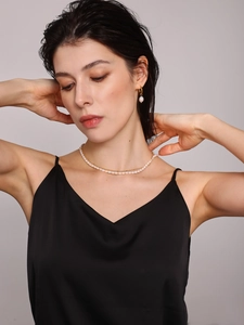 Close-up of double-layer stainless steel pearl necklace and drop earrings on a model