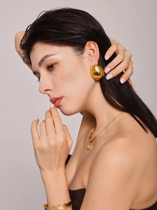 Nahaufnahme minimalistischer goldener geometrischer Ohrstecker und Halskette am Modell