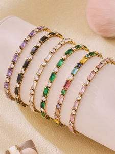 Dettaglio macro di bracciali tennis con zirconi colorati taglio baguette su supporto
