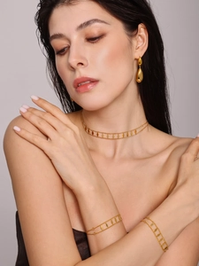 Close-up of double-layered rhombus sequin choker and matching gold jewelry set on model