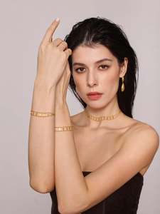 Model wearing gold double-layered geometric diamond pendant necklace and bracelet set
