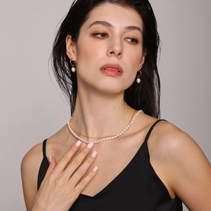 Layered pearl necklace with gold chain and drop pearl earrings set on model