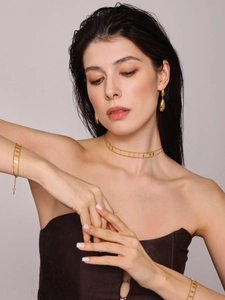 Close-up of double-layer diamond-shaped necklace and drop earring set in 18k gold